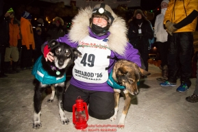 Mary Helwig at the Nome finish line finishes last to claim the red lantern award and was the one to extinquish the Widow's lamp during the 2016 Iditarod.  Alaska    

Photo by Jeff Schultz (C) 2016  ALL RIGHTS RESERVED