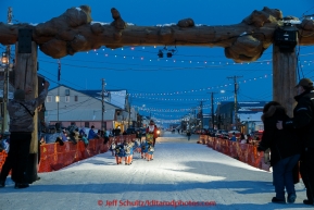 Alan Eischens runs into the finish chute and under the burl arch in Nome on Saturday March 21, 2015 during Iditarod 2015.  (C) Jeff Schultz/SchultzPhoto.com - ALL RIGHTS RESERVED DUPLICATION  PROHIBITED  WITHOUT  PERMISSION
