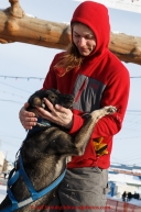 Rohn Buser plays with Berretta, one of the dogs run to Nome by Alan Stevens at the finish line in Nome on Saturday March 21, 2015 during Iditarod 2015.  (C) Jeff Schultz/SchultzPhoto.com - ALL RIGHTS RESERVED DUPLICATION  PROHIBITED  WITHOUT  PERMISSION