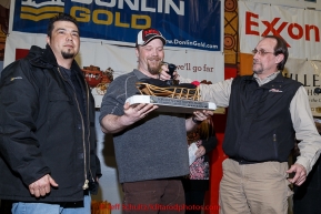 Aaron Burmeister (center) recieves the GCI Dorothy G. Page Halfway award from Dave Fancott and Greg Menendez of GCI at the finishers banquet in Nome on Sunday  March 22, 2015 during Iditarod 2015.  (C) Jeff Schultz/SchultzPhoto.com - ALL RIGHTS RESERVED DUPLICATION  PROHIBITED  WITHOUT  PERMISSION