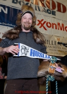 Aaron Burmeister shows off his native-made gifts from the villagers of Huslia for being the first musher to their half-way checkpoint at the finishers banquet in Nome on Sunday  March 22, 2015 during Iditarod 2015.  (C) Jeff Schultz/SchultzPhoto.com - ALL RIGHTS RESERVED DUPLICATION  PROHIBITED  WITHOUT  PERMISSION