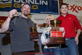 Aaron Burmeister recieves the Wells Fargo Bank Gold Coast award from Jake Slingsby and Jessica Osgood at the finishers banquet in Nome on Sunday  March 22, 2015 during Iditarod 2015.  (C) Jeff Schultz/SchultzPhoto.com - ALL RIGHTS RESERVED DUPLICATION  PROHIBITED  WITHOUT  PERMISSION