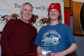 Travis Beals (R)  recieves the Horizon Lines Most Improved musher award from John Schweiken at the finishers banquet in Nome on Sunday  March 22, 2015 during Iditarod 2015.  (C) Jeff Schultz/SchultzPhoto.com - ALL RIGHTS RESERVED DUPLICATION  PROHIBITED  WITHOUT  PERMISSION