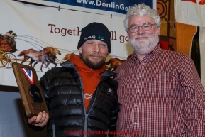 Jason Mackey (L) recieves the ExxonMobil Musher's Choice   award from Russell Tait at the finishers banquet in Nome on Sunday  March 22, 2015 during Iditarod 2015.  (C) Jeff Schultz/SchultzPhoto.com - ALL RIGHTS RESERVED DUPLICATION  PROHIBITED  WITHOUT  PERMISSION