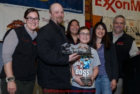 Aaron Burmeister recieves the Northern Air Cargo Herbie Nayokpuk award from Dave Karp, Sami Glascott and Cheryl Johnson of NAC as well as Michelle Bonham (Herbies grand daughter) and Bethany Thomas (Herbie's great-granddaughter) at the finishers banquet in Nome on Sunday  March 22, 2015 during Iditarod 2015.  (C) Jeff Schultz/SchultzPhoto.com - ALL RIGHTS RESERVED DUPLICATION  PROHIBITED  WITHOUT  PERMISSION