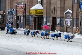 Cindy Gallea runs down Front Street and waves to a race fan taking her picture on her way to the finish line in Nome on Sunday  March 22, 2015 during Iditarod 2015.  (C) Jeff Schultz/SchultzPhoto.com - ALL RIGHTS RESERVED DUPLICATION  PROHIBITED  WITHOUT  PERMISSION
