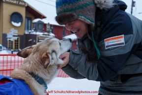 Linda Clarke, wife of musher Lachlan Clarke, gives one of their dogs attention at  the Nome finish chute shorlty after Lachlan finished on Sunday  March 22, 2015 during Iditarod 2015.  (C) Jeff Schultz/SchultzPhoto.com - ALL RIGHTS RESERVED DUPLICATION  PROHIBITED  WITHOUT  PERMISSION