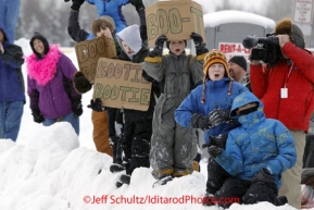 Saturday, March 3, 2012  Young fans hold signs requesting dog booties near the Alaska Native Hospital along the Ceremonial Start route of Iditarod 2012 in Anchorage, Alaska.