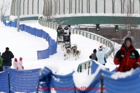 Saturday, March 3, 2012  Lachlan Clarke enjoys a hot dog while crossing the Tudor Road bridge during the Ceremonial Start of Iditarod 2012 in Anchorage, Alaska.