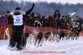 Cindy Abbott waves to the crowd as she leaves the start line during the restart on Willow lake during the Iditarod sled dog race Sunday, March 3, 2013.