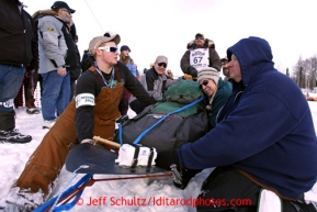 Volunteers hold the sled for veteran musher Sonny Lindner at the start line during the restart on Willow lake during the Iditarod sled dog race Sunday, March 3, 2013.