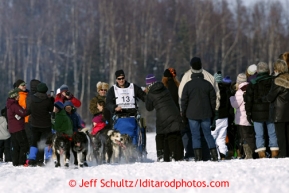 John Baker weaves his team through fans on Long Lake during the restart in Willow of the Iditarod sled dog race Sunday, March 3, 2013.