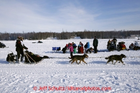 Spectators watch teams including Gerry Willomitzer on Long Lake after leaving the re-start line of the Iditarod sled dog race in Willow, Alaska Sunday, March 3, 2013.