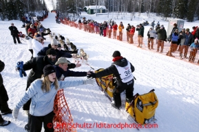 Mitch Seavey gives high-fives to fans lining the chute on Willow Lake as he leaves the restart of the Iditarod sled dog race Sunday, March 3, 2013.