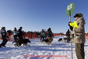 Sunday, March 4, 2012  Maryann Capps holds a "Stop/Go" sign at the restart of Iditarod 2012 in Willow, Alaska.