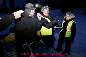 Volunteers Tim Johnson, center, with Leslie Washburn, right, check in John Baker in the morning at the Finger Lake checkpoint Monday, March 4, 2013.