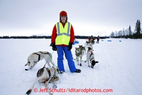 A volunteer holds onto Wade Marr's team at the Finger Lake checkpoint March 4, 2013.