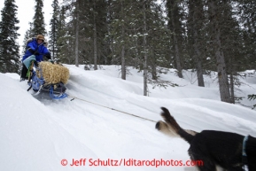 Karin Henrickson leaves with a bale of hay on her seld near Finger Lake checkpoint March 4, 2013.