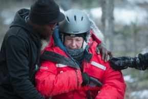 Newton Marshall hugs and comforts Yvonne Dabakk after her ride down the Dalzell Gorge and arrives in Rohn on Tuesday March 4 during Iditarod 2014 . PHOTO BY JEFF SCHULTZ/IDITARODPHOTOS.COM  USE ONLY WITH PERMISSION