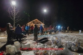 Volunteers hold Dan Kaduce 's team as they check in at Rohn on Monday March 3 during Iditarod 2014 . PHOTO BY JEFF SCHULTZ/IDITARODPHOTOS.COM  USE ONLY WITH PERMISSION