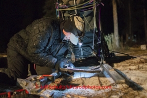 Jessie Royer fixes her drag break which broke on the trip through the Dalzell Gorge on Monday March 3 during Iditarod 2014 . PHOTO BY JEFF SCHULTZ/IDITARODPHOTOS.COM  USE ONLY WITH PERMISSION