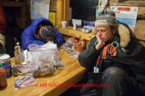 Rohn Volunteers, up all night with teams, sleep at the table in the early morning on Tuesday March 4 during Iditarod 2014 . PHOTO BY JEFF SCHULTZ/IDITARODPHOTOS.COM  USE ONLY WITH PERMISSION