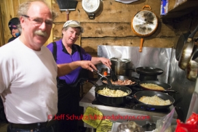 Bruce and Diana Morony cook breakfast for the group of volunteers at the Rohn checkpoint on Tuesday March 4 during Iditarod 2014 . PHOTO BY JEFF SCHULTZ/IDITARODPHOTOS.COM  USE ONLY WITH PERMISSION