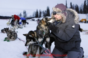 Monday March 5, 2012  A vet gets a kiss from one of the dogs resting at the Finger Lake checkpoint during Iditarod 2012.