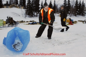 Monday March 5, 2012  Volunteer Mark Green of Canton, Ohio, cleans up as Chris Goodwin of Seward helps out at the Finger Lake checkpoint during Iditarod 2012.