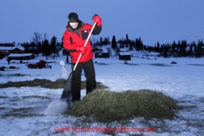 Monday March 5, 2012  First year volunteer Eric Peterson rakes hay after a team left the Rainy Pass checkpoint, Iditarod 2012.