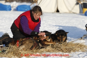 Kelley Griffin boots her dogs at the Nikolai checkpoint March 5, 2013.