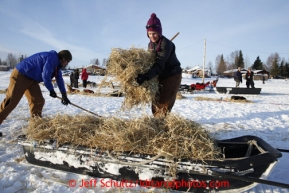 Trail helpers Kara Wortley, right, and Micah Rydman clean up straw at the Nikolai checkpoint March 5, 2013.