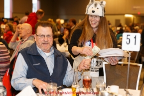 Banquet volunteer Karen Tallent sells a $100 raffle ticket to a race fan at the musher  banquet & drawing on Thursday March 5, 2015 at the Denaina Center in Anchorage, Alaska.  Iditarod 2015 (C) Jeff Schultz/SchultzPhoto.com - ALL RIGHTS RESERVED DUPLICATION  PROHIBITED  WITHOUT  PERMISSION