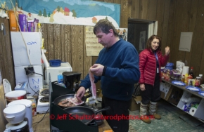 Volunteer vet Michael Walker does double duty as a breakfast cook at Nikolai on Wednesday March 5 during the 2014 IditarodPHOTO BY JEFF SCHULTZ / IDITARODPHOTOS.COM  DO NOT REPRODUCE WITHOUT PERMISSION