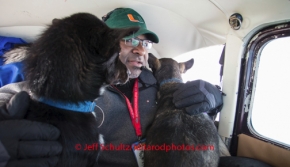 Veterinarian Bruce Nwadike holds onto two dropped dogs inside volunteer pilot Bruce Maroney 's airplane on a flight from Nikolai to McGrath checkpoint on Wednesday March 5 , 2014 during the 2014 IditarodPHOTO BY JEFF SCHULTZ / IDITARODPHOTOS.COM  DO NOT REPRODUCE WITHOUT PERMISSION