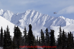 Tuesday March 6, 2012 An airplane from the Iditarod airforce circles the Rainy Pass checkpoint and looks small in comparison to the mountains in the Alaska Range, Iditarod 2012.