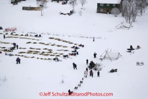 Tuesday March 6, 2012 Aerial view of Josh Cadzow's team coming off the Kuskokwim River and entering the Nikolai checkpoint, Iditarod 2012.