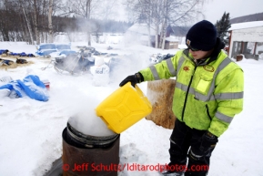 Takotna volunteer Ryan Goods fills up the can to keep water hot for mushers at the Takotna checkpoint on Wednesday March 6, 2013.Iditarod Sled Dog Race 2013Photo by Jeff Schultz copyright 2013 DO NOT REPRODUCE WITHOUT PERMISSION