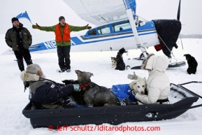 Pilot Greg Fischer, in orange vest, welcomes a sledload of dropped dogs at the airstrip in on Wednesday March 6, 2013.Iditarod Sled Dog Race 2013Photo by Jeff Schultz copyright 2013 DO NOT REPRODUCE WITHOUT PERMISSION