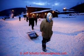 Larry Fox drags a sled load of food to Cindy Gallea's team at the Takotna checkpoint on Wednesday March 6, 2013.Iditarod Sled Dog Race 2013Photo by Jeff Schultz copyright 2013 DO NOT REPRODUCE WITHOUT PERMISSION