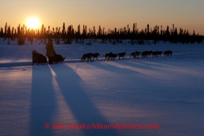 Rookie musher Katherine Keith runs on the trail on the way to  the Cripple checkpoint at sunset, Thursday, March 6, during the Iditarod Sled Dog Race 2014.PHOTO (c) BY JEFF SCHULTZ/IditarodPhotos.com -- REPRODUCTION PROHIBITED WITHOUT PERMISSION