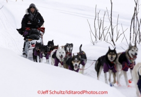 Wednesday March 7, 2012  Curt Perano runs up off the Takotna river with a dog in his sled bag just befor the Takotna checkpoint.  Iditarod 2012.