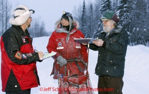 Wednesday March 7, 2012   Volunteer Comms, Rob Johnson (L) helps check in Braxton Peterson with McGrath resident and checker Steve Kovach in the early morning at the McGrath checkpoint. Iditarod 2012.