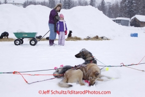 Wednesday March 7, 2012  Holly Carson (L) and her grand daughter Catherine Carson watches Trent Herbst dogs rest at the McGrath checkpoint. Iditarod 2012.