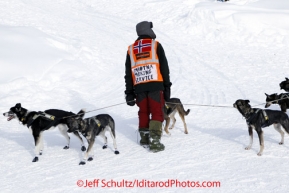 Wednesday March 7, 2012   One of a group of Norwegian exchange students volunteering as a dog-team parker, holds onto Mike Santos team at the Takotna checkpoint Iditarod 2012.