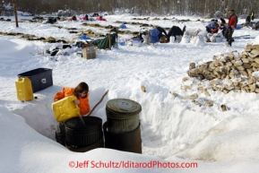 Wednesday March 7, 2012    15 year old Takotna resident Sabrina Anselment pours water into a garbage can, turned water heater.  Mushers that rest in Takotna are treated to the luxury of ready-made hot water.   Iditarod 2012.