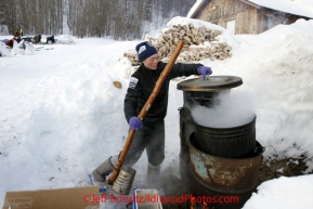 Wednesday March 7, 2012  Musher Sigrid Ekran scoops hot water from the pot at the Takotna checkpoint Iditarod 2012.