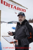 Volunteer Kelly Vanmeter mans the checksheet to check in teams at the halfway checkpoint of Iditarod on Thursday March 7, 2013.Iditarod Sled Dog Race 2013Photo by Jeff Schultz copyright 2013 DO NOT REPRODUCE WITHOUT PERMISSION