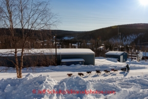 Paige Drobny runs up the road as she arrives in Ruby on Friday, March 7, during the Iditarod Sled Dog Race 2014.PHOTO (c) BY JEFF SCHULTZ/IditarodPhotos.com -- REPRODUCTION PROHIBITED WITHOUT PERMISSION