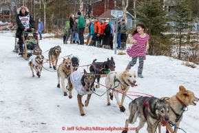 Young Hanna Swircenski runs next to Becca Moore's team as she runs down the bike/ski trail during the cermonial start day of Iditarod 2015 in Anchorage, Alaska. Saturday March 7, 2015(C) Jeff Schultz/SchultzPhoto.com - ALL RIGHTS RESERVED DUPLICATION  PROHIBITED  WITHOUT  PERMISSION